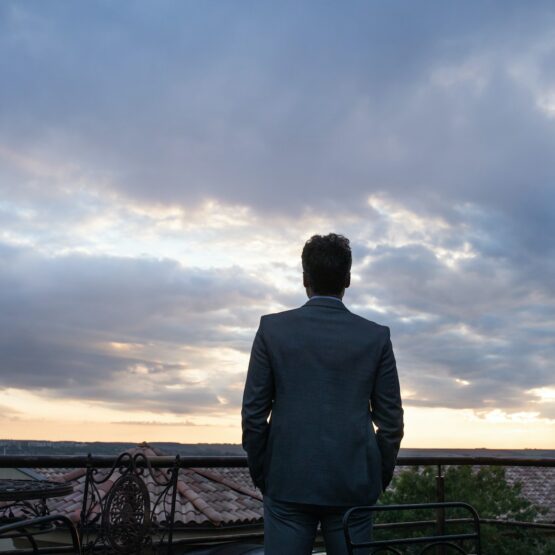 Mature businessman standing in a hotel balcony.