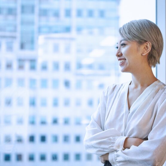 Portrait of businesswoman looking out of window smiling