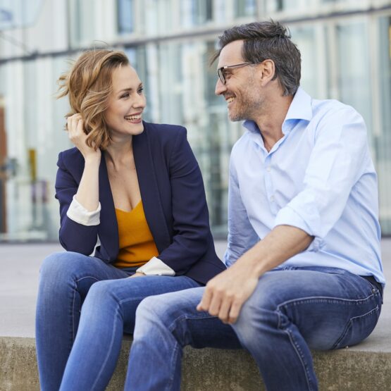 Two business people sitting outdoors talking