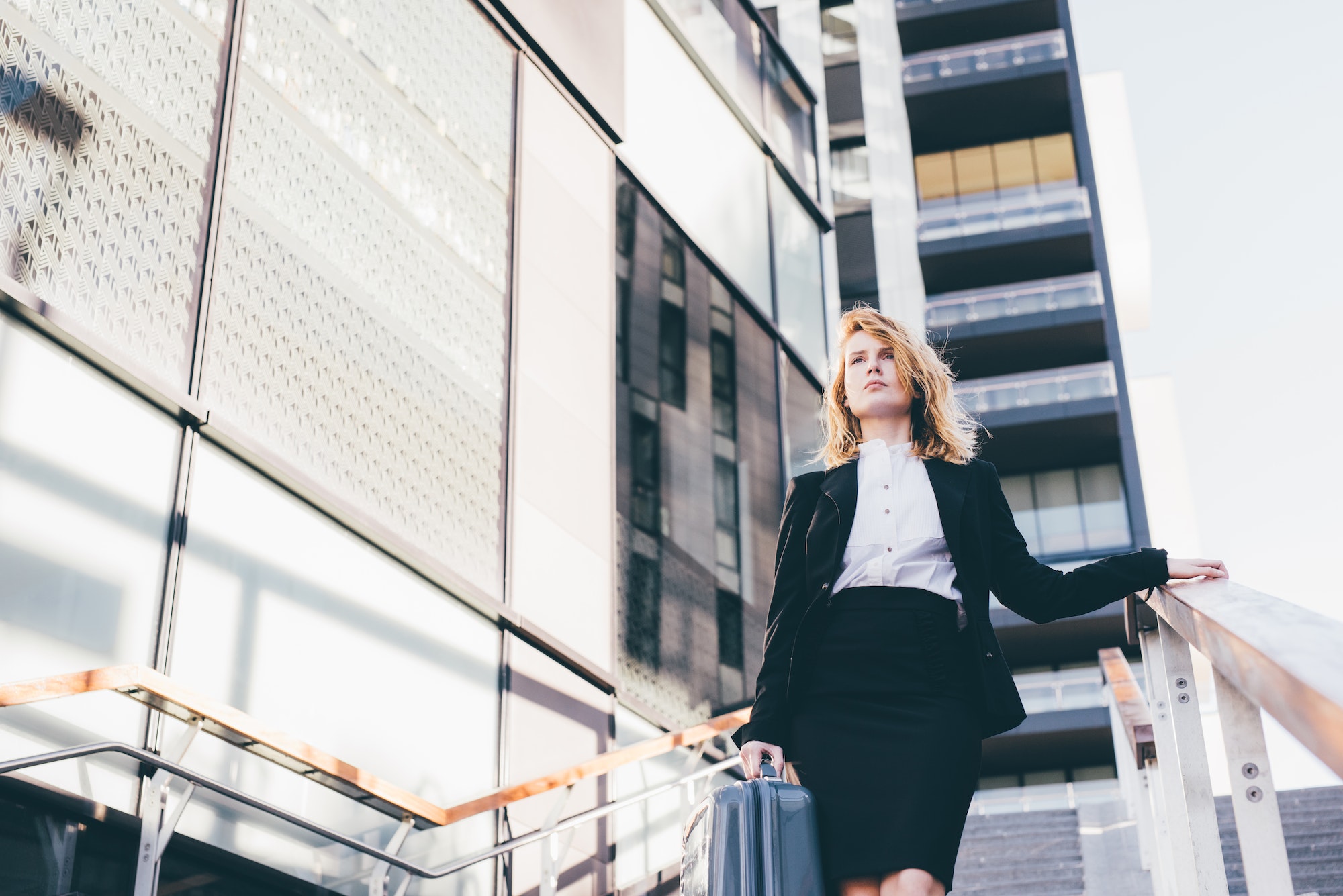 young contemporary businesswoman walking downstais